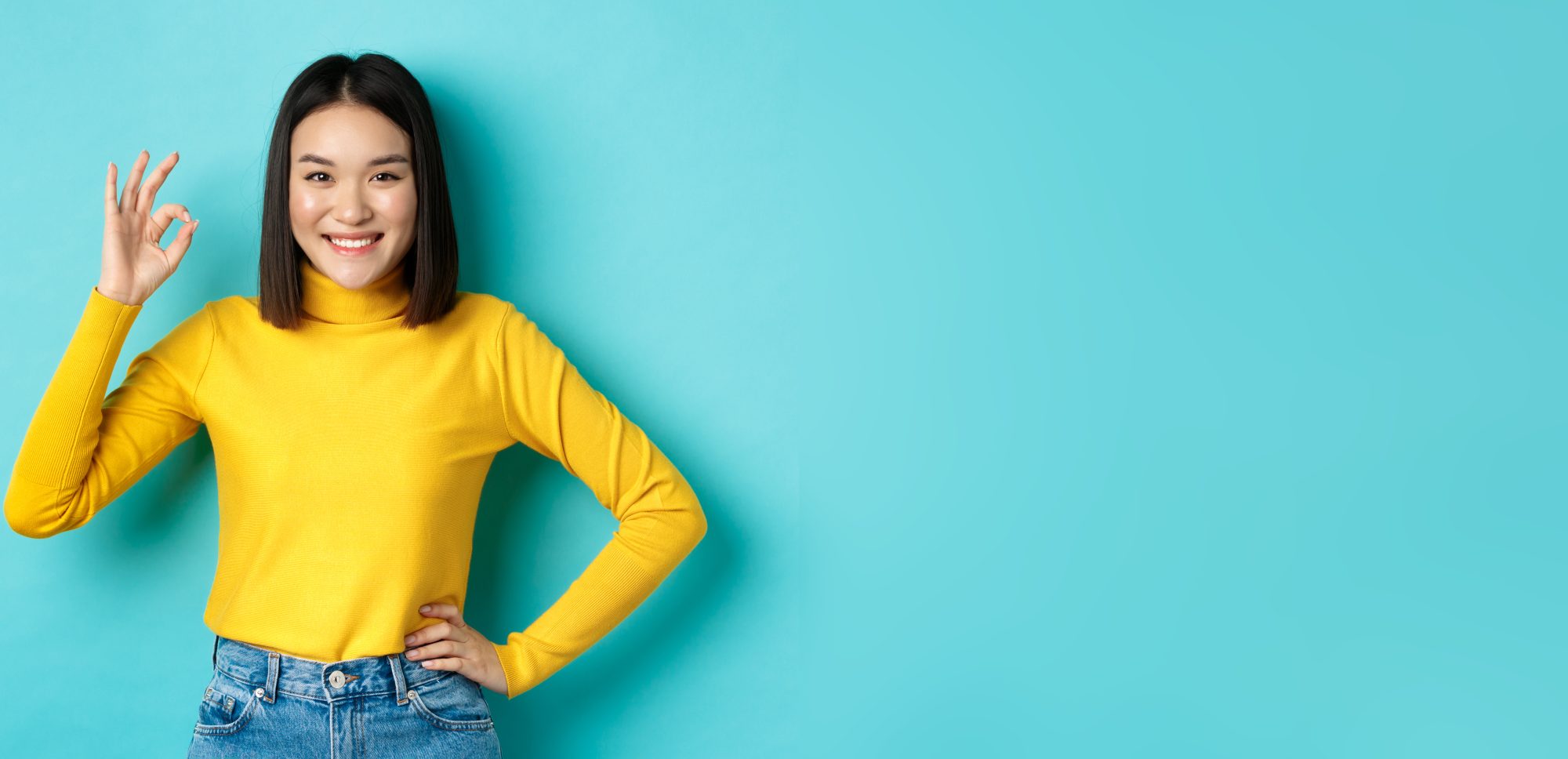 Elyxa Australian Organic Whole-food Supplements Happy Beautiful Asian Woman Smiling, Showing Okay Gesture In Approval, Saying Yes, Standing Pleased Over Blue Background