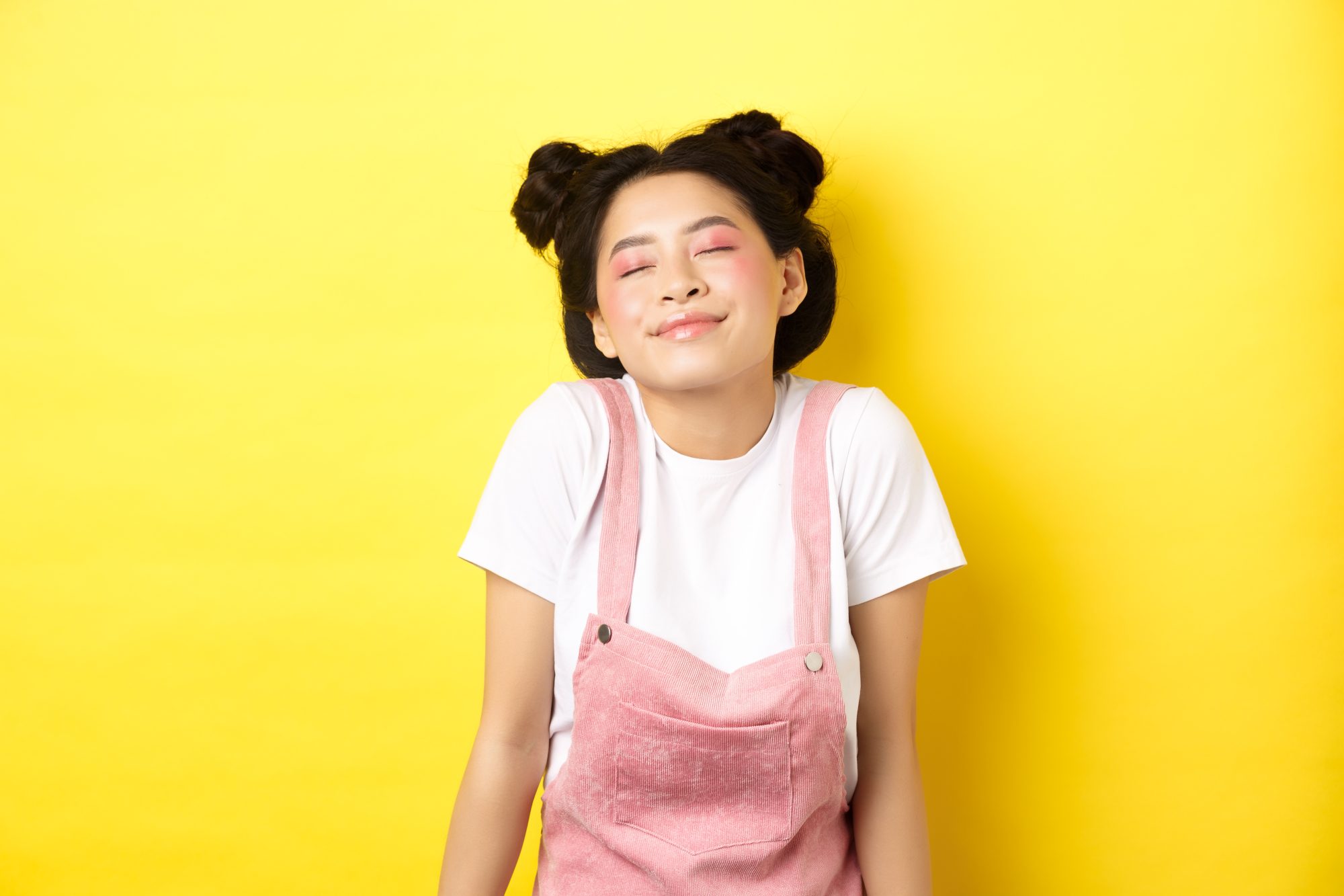 Elyxa Australian Organic Whole-food Supplements Romantic Asian Girl With Cute Pink Makeup And Summer Clothes, Close Eyes And Smiling Dreamy, Standing On Yellow Background